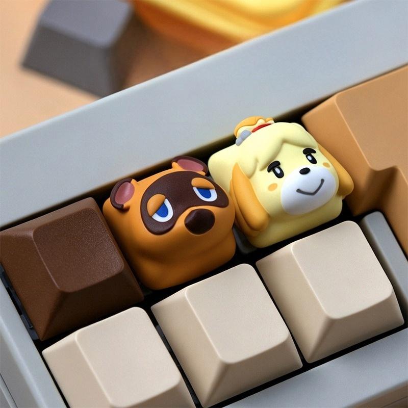 Tom Nook and Isabelle keycaps photographed from an angle on a keyboard | SIMPOCUBIC