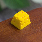 Yellow cheese keycap photographed on a wooden table | SIMPOCUBIC