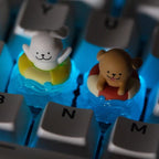 Two swim-ring puppy keycaps fitted on a blue keyboard | SIMPOCUBIC