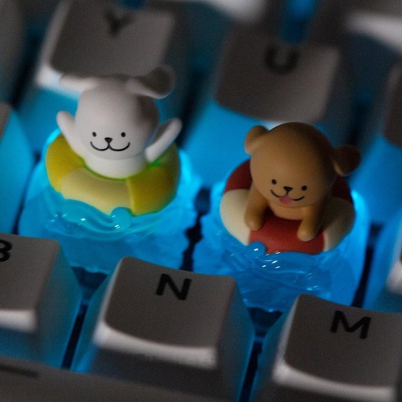 Two swim-ring puppy keycaps fitted on a blue keyboard | SIMPOCUBIC