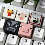 Minecraft cow, chicken, wolf, sheep and pig keycaps together on a white keyboard