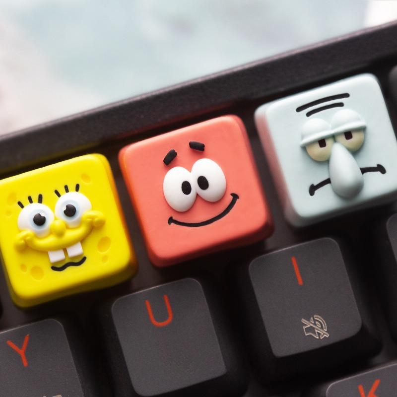 SpongeBob, Patrick and Squidward character keycaps on a black keyboard