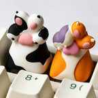 Orange and white cat paw and black and white dog paw keycaps on a keyboard