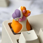 Orange and white cat paw single keycap on a keyboard